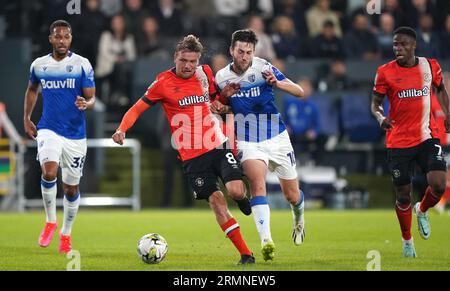 Luke Berry di Luton Town (a sinistra) e Ashley Nadesan di Gillingham si battono per il pallone durante il secondo turno della Carabao Cup a Kenilworth Road, Luton. Data foto: Martedì 29 agosto 2023. Foto Stock