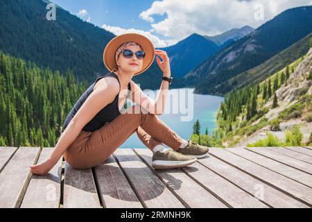 Bella donna che posa sul lago Kolsay, nelle montagne del Kazakistan. Natura dell'Asia centrale, turismo domestico, concetto di vacanza Foto Stock
