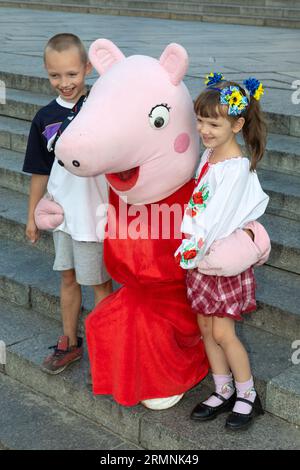 I bambini vengono fotografati con personaggi dei cartoni animati durante una mostra di attrezzature militari distrutte. Una "parata" di equipaggiamento russo rotto è stata organizzata su Khreshchatyk a Kiev per celebrare il giorno dell'indipendenza dell'Ucraina, carri armati bruciati, veicoli corazzati e frammenti di missili russi sono stati esposti su Khreshchatyk nel centro di Kiev. Questo è il modo in cui la capitale Ucraina ha celebrato il giorno dell'indipendenza il 24 agosto. Foto Stock