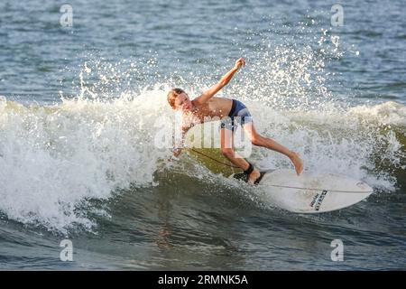 Isola di Palms, Stati Uniti. 29 agosto 2023. Un giovane surfista cavalca un'onda più alta del normale surf causata dal passaggio dell'uragano Franklin ha portato insolite azioni ondulate sulla costa atlantica, il 29 agosto 2023 a Isle of Palms, Carolina del Sud. L'uragano Franklin, una tempesta di mostri di categoria 4 si dirige alle Bermuda, mentre l'uragano Idalia dovrebbe sorvolare giovedì. Crediti: Richard Ellis/Richard Ellis/Alamy Live News Foto Stock