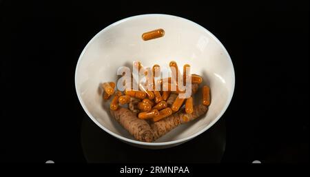 Curcuma, curcuma Longa, Capsule che cadono su sfondo nero, spezie indiane Foto Stock