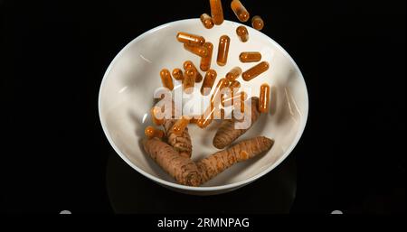 Curcuma, curcuma Longa, Capsule che cadono su sfondo nero, spezie indiane Foto Stock