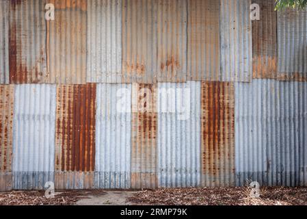 Una parete in stile industriale di fogli ondulati arrugginiti Foto Stock