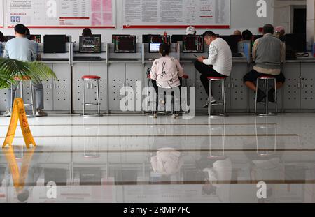 Fuyang, Cina. 28 agosto 2023. Diversi investitori stanno prestando attenzione alle modifiche dell'indice composito di Shanghai visualizzate sugli schermi del Fuyang Huaa'an Securities Trading Office. Il ministero delle Finanze e l'amministrazione fiscale dello Stato hanno annunciato in una dichiarazione dell'agosto 27 che la Cina avrebbe dimezzato l'imposta di bollo sulle transazioni azionarie dall'agosto 28 per rivitalizzare i mercati dei capitali e aumentare la fiducia degli investitori. (Foto di Sheldon Cooper/SOPA Images/Sipa USA) credito: SIPA USA/Alamy Live News Foto Stock