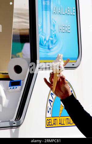 Un cliente prende un gelato Flake del 99 con piccoli chicchi di cioccolato al latte aggiunti, da una botola di un distributore di gelati, partecipando a uno spettacolo gastronomico, agosto 2023. Foto Stock