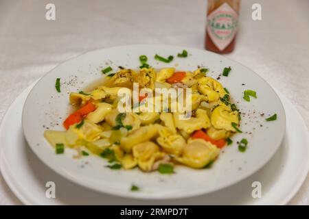 Tradizionale zuppa italiana di tortellini (capeletti, agnolini) con pollo e verdure, zuppa speciale per serate fredde Foto Stock