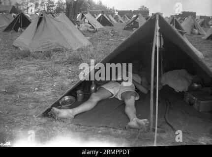 Soldato che dorme nella tenda dell'esercito al campo tenda. I membri della 114a divisione di fanteria dell'esercito degli Stati Uniti si addestrano a combattere contro la Germania in Europa durante la seconda guerra mondiale. Foto Stock