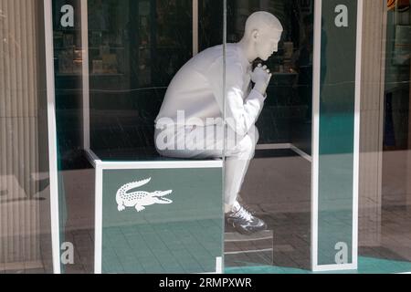 Bordeaux , Francia - 08 19 2023 : lacoste logo, catena di insegne testuali e manichino vestito di bianco sulla facciata del muro, ingresso del negozio in città Foto Stock