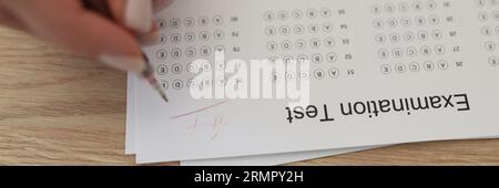 Mani mettere una penna sul test di esame, un primo piano Foto Stock
