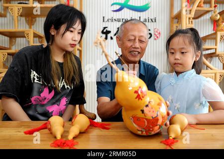 Un artigiano espone le sue opere d'arte della zucca nella città di Laixi, nella provincia dello Shandong della Cina orientale, il 27 agosto 2023. Foto Stock