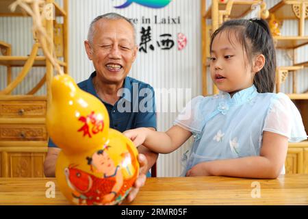 Un artigiano espone le sue opere d'arte della zucca nella città di Laixi, nella provincia dello Shandong della Cina orientale, il 27 agosto 2023. Foto Stock