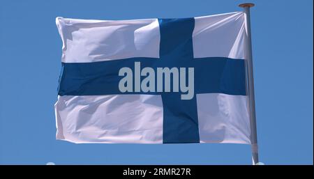 Bandiera finlandese che sventola nel vento contro il cielo blu Foto Stock