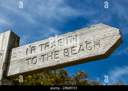 Un cartello di legno che dice in inglese e gallese 'alla spiaggia' 'ir Traeth' Traeth Porthor, penisola llyn, gwynedd, Galles Foto Stock