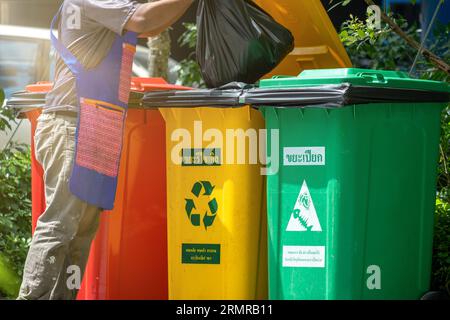 Persone che gettano un po' di spazzatura in un cestino. Il concetto di riciclaggio da parte dell'uomo separa i rifiuti prima dello smaltimento per salvaguardare l'ambiente. Foto Stock