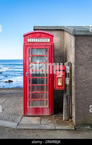 Iconica cabina telefonica rossa britannica tradizionale e casella postale Royal mail sul lungomare di Pennan, Aberdeenshire, Scozia, affacciato sul Mare del Nord. Foto Stock