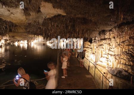 Manacor, Spagna. 28 agosto 2023. I visitatori delle grotte del Drago a Porto Cristo, uno dei luoghi più visitati di Maiorca. Con un'altezza massima di 25 metri sotto la superficie, il percorso è lungo circa 1,2 chilometri e presenta un gran numero di stalattiti e stalagmiti. Le grotte si nascondono in un grande lago sotterraneo, il lago Martel, considerato uno dei più grandi laghi sotterranei del mondo. Crediti: Clara Margais/dpa/Alamy Live News Foto Stock