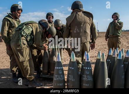 FRONTIERA DI GAZA, luglio 2014 (Xinhua) - i soldati israeliani preparano proiettili per un obice semovente M109 Dores da 155 mm nel campo nel sud di Israele vicino al confine con Gaza, il decimo giorno dell'operazione bordo protettivo, il 17 luglio 2014. L'esercito israeliano ha lanciato un'offensiva di terra sulla Striscia di Gaza controllata da Hamas giovedì sera, dopo giorni di pesanti bombardamenti, ha detto l'esercito. (Xinhua/li Rui) OPERAZIONE ISRAELE-FRONTIERA DI GAZA-TERRA ALL'INTERNO DI GAZA-LANCIO PUBLICATIONxNOTxINxCHN frontiera di Gaza luglio 2014 i soldati israeliani XINHUA preparano conchiglie per un obice semovente da 155 mm M109 Dores Foto Stock