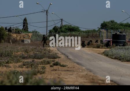 FRONTIERA DI GAZA, luglio 2014 (Xinhua) -- due soldati israeliani cambiano posizione durante un fuoco incrociato con militanti palestinesi nel campo del sud di Israele vicino al confine con Gaza, il decimo giorno dell'operazione bordo protettivo, il 17 luglio 2014. Otto militanti palestinesi sono stati uccisi da soldati israeliani durante un fuoco incrociato qui giovedì, quando i militanti sono stati trovati per entrare in Israele. L'esercito israeliano ha lanciato un'offensiva di terra sulla Striscia di Gaza controllata da Hamas giovedì sera, dopo giorni di pesanti bombardamenti, ha detto l'esercito. (Xinhua/li Rui) ISRAELE-GAZA-FRONTIERA-CROSSFIRE PUBLICAT Foto Stock