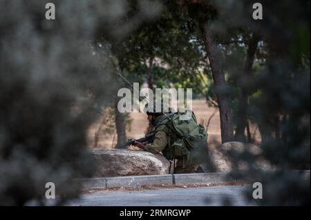 Un soldato israeliano prende posizione durante un'operazione in un avamposto nel sud di Israele vicino al confine con Gaza, il 19 luglio 2014, il dodicesimo giorno dell'operazione bordo protettivo. Gli scioperi israeliani hanno ucciso 20 persone a Gaza sabato, prendendo il bilancio delle vittime da un bombardamento di 12 giorni a 318, mentre il capo delle Nazioni Unite Ban Ki-Moon si è diretto nella regione per unirsi agli sforzi di tregua. (Xinhua/li Rui)(zhf) ISRAEL-GAZA-BORDER-CONFLICT PUBLICATIONxNOTxINxCHN to Israeli Soldier prende posizione durante l'operazione ALL'avamposto nel sud di Israele vicino al confine con Gaza IL 19 luglio 2014, dodicesimo giorno dell'operazione bordo protettivo Israe Foto Stock