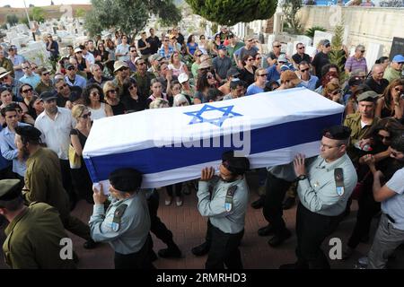 I soldati israeliani portano la bara del maggiore Amotz Greenberg, un soldato di riserva di 45 anni ucciso combattendo un gruppo di militanti palestinesi che si sono infiltrati in Israele attraverso un tunnel dal centro della Striscia di Gaza, durante il suo funerale a Hod Hasharon, vicino a Tel Aviv, in Israele, il 20 luglio 2014. Tredici soldati israeliani sono stati uccisi durante la notte e la prima domenica in scontri con militanti palestinesi in tutta la Striscia di Gaza, in mezzo all'incursione terrestre dell'esercito israeliano nell'enclave, le forze di difesa israeliane (IDF) hanno confermato in una dichiarazione. (XINHUA/JINI) ISRAEL-GAZA-GROUND OPERATION-13 ISRAELI SOLDIERS-K. Foto Stock