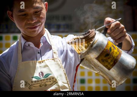 (140728) - HONG KONG, 28 luglio 2014 (Xinhua) -- Uno chef di tè al latte prepara tè al latte in stile Hong Kong a Causeway Bay nel sud della Cina a Hong Kong, 28 luglio 2014. Per celebrare il fatto che il tè al latte in stile Hong Kong figura nell'elenco del primo inventario del patrimonio culturale immateriale di Hong Kong, annunciato dal dipartimento per i servizi culturali e il tempo libero di Hong Kong il 17 giugno 2014, l'Associazione del caffè e del tè di Hong Kong ha invitato gli chef del tè al latte a mostrare le capacità di preparazione del tè al latte al Causeway Bay Lunedi'. (Xinhua/lui Siu Wai)(wjq) CHINA-HONG KONG-MILK TEA-CULTURAL HERITAGE (CN) PUBLICATIONxNOTxINxCHN H Foto Stock