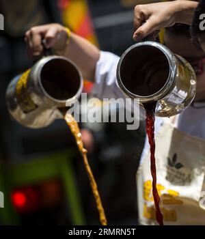 (140728) - HONG KONG, 28 luglio 2014 (Xinhua) -- gli chef di tè al latte preparano il tè al latte di Hong Kong a Causeway Bay nella Cina meridionale a Hong Kong, 28 luglio 2014. Per celebrare il fatto che il tè al latte in stile Hong Kong figura nell'elenco del primo inventario del patrimonio culturale immateriale di Hong Kong, annunciato dal dipartimento per i servizi culturali e il tempo libero di Hong Kong il 17 giugno 2014, l'Associazione del caffè e del tè di Hong Kong ha invitato gli chef del tè al latte a mostrare le capacità di preparazione del tè al latte al Causeway Bay Lunedi'. (Xinhua/lui Siu Wai)(wjq) CHINA-HONG KONG-MILK TEA-CULTURAL HERITAGE (CN) PUBLICATIONxNOTxINxCHN Hon Foto Stock