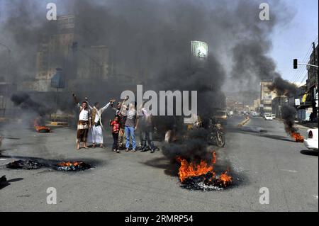 (140730) -- SANAA, 30 luglio 2014 -- gli yemeniti bruciano pneumatici per protestare contro la decisione del governo di aumentare drasticamente il prezzo del carburante a Sanaa, Yemen, il 30 luglio 2014. Il governo yemenita aumentò il prezzo della benzina da 125 riyal yemeniti (0,58 dollari USA) a 200 riyal per litro e sbarcò da 100 riyal a 195 riyal mercoledì, cosa che ha scatenato proteste di massa nella capitale Sanaa. I manifestanti arrabbiati bruciarono pneumatici e tagliarono molte strade a Sanaa. Il governo ha schierato più soldati per mantenere la sicurezza nella capitale. ) (DZL) YEMEN-SANAA-PREZZO DELLA BENZINA-PROTESTA MOHAMMEDXMOHAMMED P. Foto Stock