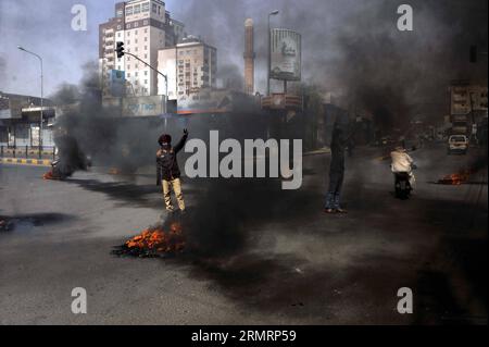 (140730) -- SANAA, 30 luglio 2014 -- gli yemeniti bruciano pneumatici per protestare contro la decisione del governo di aumentare drasticamente il prezzo del carburante a Sanaa, Yemen, il 30 luglio 2014. Il governo yemenita aumentò il prezzo della benzina da 125 riyal yemeniti (0,58 dollari USA) a 200 riyal per litro e sbarcò da 100 riyal a 195 riyal mercoledì, cosa che ha scatenato proteste di massa nella capitale Sanaa. I manifestanti arrabbiati bruciarono pneumatici e tagliarono molte strade a Sanaa. Il governo ha schierato più soldati per mantenere la sicurezza nella capitale. ) (DZL) YEMEN-SANAA-PREZZO DELLA BENZINA-PROTESTA MOHAMMEDXMOHAMMED P. Foto Stock