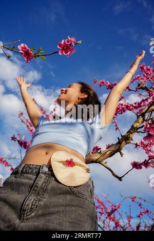 Giovane donna che celebra il recupero del cancro in natura. Concetto di resilienza, sopravvivenza e visibilità Foto Stock