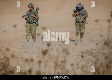 (140805) -- FRONTIERA DI GAZA, 4 agosto 2014 -- i soldati israeliani camminano nel sud di Israele al confine con la Striscia di Gaza dopo essere tornati dall'enclave palestinese 4 agosto 2014. Israele ha accettato una proposta egiziana per un cessate il fuoco di 72 ore con il movimento palestinese di Hamas a partire dalle 8:00 ora locale (0500 GMT) di martedì, i media israeliani hanno riferito lunedì. Durante le 72 ore, una delegazione israeliana dovrebbe arrivare al Cairo, capitale dell'Egitto, per negoziare con i palestinesi, ha riportato il sito di notizie di Walla. ACCORDO DI CESSATE IL FUOCO DI 72 ORE PER ISRAELE-STRISCIA DI GAZA-JINI PUBLICATIONXNOTXINXCHN Foto Stock