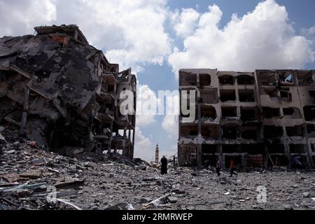 (140804) -- STRISCIA DI GAZA, 4 agosto 2014 -- Una donna palestinese si trova di fronte a edifici distrutti dalle forze militari israeliane nella città settentrionale di Beit Lahiya, nella Striscia di Gaza, il 4 agosto 2014. Dall'inizio dell'offensiva israeliana sulla Striscia di Gaza, 1.868 palestinesi sono stati uccisi e più di 9470 feriti, ha detto Ashraf al-Qedra, portavoce del ministero della salute a Gaza. ) MIDEAST-GAZA-ISRAELE-CESSATE IL FUOCO WissamxNassar PUBLICATIONxNOTxINxCHN Striscia di Gaza 4 agosto 2014 una donna PALESTINESE si trova di fronte agli edifici distrutti dalle forze militari israeliane nella città settentrionale di BEI nella Striscia di Gaza Foto Stock