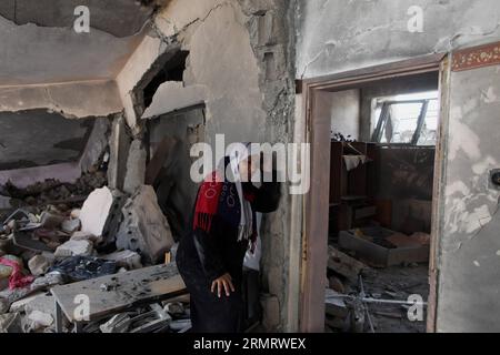 (140804) -- STRISCIA DI GAZA, 4 agosto 2014 -- Una donna palestinese si trova nella sua casa distrutta dalle forze militari israeliane nella città settentrionale della Striscia di Gaza di Beit Hanoun, il 4 agosto 2014. Dall'inizio dell'offensiva israeliana sulla Striscia di Gaza, 1.868 palestinesi sono stati uccisi e più di 9470 feriti, ha detto Ashraf al-Qedra, portavoce del ministero della salute a Gaza. ) MIDEAST-GAZA-ISRAELE-CESSATE IL FUOCO WissamxNassar PUBLICATIONxNOTxINxCHN Striscia di Gaza 4 agosto 2014 una donna PALESTINESE si trova nella sua casa distrutta dalle forze militari israeliane nella città di Beit Hanoun NELLA Striscia di Gaza settentrionale IL 4 agosto Foto Stock