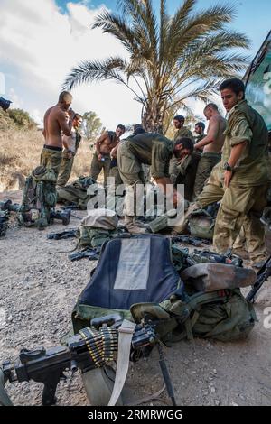 (140805) -- FRONTIERA DI GAZA, 4 agosto 2014 -- i soldati israeliani riposano nel sud di Israele al confine con la Striscia di Gaza dopo essere tornati dall'enclave palestinese 4 agosto 2014. Israele ha accettato una proposta egiziana per un cessate il fuoco di 72 ore con il movimento palestinese di Hamas a partire dalle 8:00 ora locale (0500 GMT) di martedì, i media israeliani hanno riferito lunedì. Durante le 72 ore, una delegazione israeliana dovrebbe arrivare al Cairo, capitale dell'Egitto, per negoziare con i palestinesi, ha riportato il sito di notizie di Walla. ACCORDO DI CESSATE IL FUOCO DI 72 ORE PER ISRAELE-STRISCIA DI GAZA-JINI PUBLICATIONXNOTXINXCHN Foto Stock