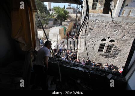 (140805) -- BETLEMME, 5 agosto 2014 -- i palestinesi ispezionano un edificio danneggiato colpito da un razzo che si ritiene sia stato lanciato da militanti palestinesi dalla Striscia di Gaza, nella città di Beit Sahour in Cisgiordania, vicino a Betlemme, all'inizio del 5 agosto 2014. Un cessate il fuoco di 72 ore nella Striscia di Gaza, mediato dall'Egitto, è entrato in vigore alle 8 del mattino, ora locale (0500 GMT) martedì, segnando l'ultimo tentativo di fermare gli scontri israelo-palestinesi dopo che i precedenti sforzi si sono conclusi con un fallimento. Luay Sababa) MIDEAST-BETHLEHEM-ROCKET EmadxDrimly PUBLICATIONxNOTxINxCHN Betlemme 5 agosto 2014 PALESTINESI ispezionano un edificio danneggiato colpito da un Foto Stock