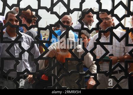 (140805) -- GAZA, 5 agosto 2014 -- palestinesi che sperano di attraversare l'Egitto, attendere il valico di Rafah tra l'Egitto e la Striscia di Gaza meridionale, 5 agosto 2014. La proposta egiziana di cessate il fuoco è stata approvata lunedì dai palestinesi e a tarda notte è stata accettata anche dal primo ministro israeliano Benjamin Netanyahu, portando una pausa tanto attesa al conflitto mortale di 29 giorni. ) MIDEAST-GAZA-RAFAH-CROSSING KhaledxOmar PUBLICATIONxNOTxINxCHN Gaza 5 agosto 2014 PALESTINESI che sperano di attraversare l'Egitto aspettano AL valico di Rafah tra l'Egitto e la Striscia di Gaza meridionale 5 agosto 2014 T. Foto Stock