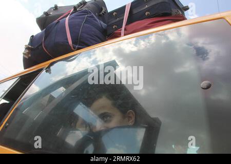 (140805) -- GAZA, 5 agosto 2014 -- Una ragazza palestinese, che spera di attraversare l'Egitto con la sua famiglia, è vista all'interno di un autobus mentre aspetta al valico di Rafah tra l'Egitto e la Striscia di Gaza meridionale, 5 agosto 2014. La proposta egiziana di cessate il fuoco è stata approvata lunedì dai palestinesi e a tarda notte è stata accettata anche dal primo ministro israeliano Benjamin Netanyahu, portando una pausa tanto attesa al conflitto mortale di 29 giorni. ) MIDEAST-GAZA-RAFAH-CROSSING KhaledxOmar PUBLICATIONxNOTxINxCHN Gaza 5 agosto 2014 una ragazza PALESTINESE che spera di entrare in Egitto con la sua famiglia È Lakes Foto Stock