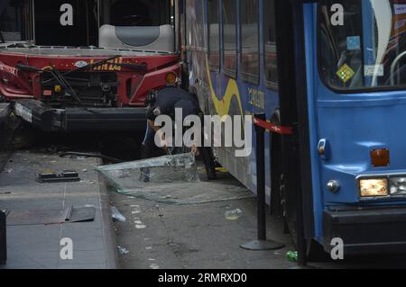 (140805) -- NEW YORK, 05 agosto 2014 -- Un funzionario del Dipartimento di polizia di New York ispeziona il sito dove due autobus si sono scontrati a Times Square, New York City, Stati Uniti, il 5 agosto 2014. Due autobus turistici si sono schiantati presso il sito ad alta densità turistica martedì, ferendo 14 persone, tre delle quali in modo critico, secondo l'ultimo rapporto. ) US-NEW YORK-TIMES SCONTRO QUADRATO-BUS QinxLang PUBLICATIONxNOTxINxCHN New York Aug 05 2014 un funzionario del Dipartimento di polizia di New York ispeziona il sito dove due autobus si sono scontrati A Times Square New York City negli Stati Uniti IL 5 agosto 2014 due visite turistiche B. Foto Stock