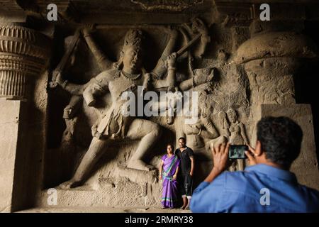 (140806) -- MAHARASHTRA, 6 agosto 2014 -- i turisti visitano le sculture in pietra indù nelle grotte di ellora vicino Aurangabad nel Maharashtra, India, 6 agosto 2014. I 34 monasteri e templi, che si estendono per più di 2 km, furono scavati fianco a fianco nel muro di un'alta scogliera di basalto, non lontano da Aurangabad, nel Maharashtra. Ellora, con la sua sequenza ininterrotta di monumenti che risalgono dal 600 d.C. al 1000, dà vita alla civiltà dell'antica India. Non solo il complesso di Ellora è una creazione artistica unica e uno sfruttamento tecnologico, ma, con i suoi santuari dedicati al buddismo, all'induismo e Foto Stock