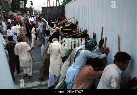 I manifestanti cercano di rimuovere un container a Lahore, Pakistan orientale, l'8 agosto 2014. La polizia pakistana ha usato proiettili di gas lacrimogeni per disperdere manifestanti anti-governativi a Lahore venerdì tardi dopo aver sequestrato un autobus della polizia, hanno detto testimoni e funzionari. Centinaia di sostenitori di un leader religioso, Tahir ul Qadri si sono scontrati con la polizia dopo aver iniziato a rimuovere i container dalle strade piazzate dalle autorità per fermare una manifestazione contro il governo il 10 agosto). PAKISTAN-LAHORE-PROTESTA Sajjad PUBLICATIONxNOTxINxCHN i manifestanti cercano di RIMUOVERE un container a Lahore nel Pakistan orientale L'8 agosto 2014 Foto Stock