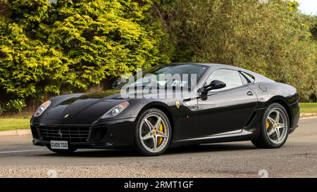 Whittlebury, Northants, Regno Unito - 27 agosto 2023: 2009 auto nera Ferrari 599 che viaggia su una strada di campagna inglese Foto Stock