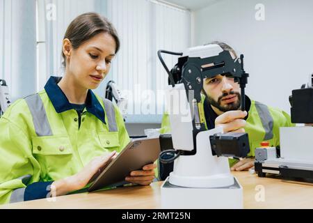 gli studenti di ingegneri automatici studiano e controllano la macchina del kit di addestramento robot in un'accademia di robotica presso un'università o un'officina di fabbrica. AI Foto Stock