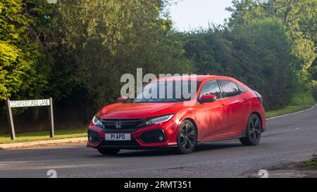 Whittlebury, Northants, Regno Unito - 27 agosto 2023: 2017 auto Honda Civic sport vtec rossa che viaggia su una strada di campagna inglese Foto Stock