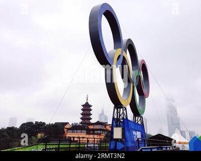 (140813) -- NANCHINO, 13 agosto 2014 -- una foto scattata il 13 agosto 2014 mostra una vista di una scultura degli anelli Olimpici insediati sulla porta Jiefangmen del muro della città di Nanchino dalla dinastia Ming e il Tempio Jiming a Nanchino, capitale della provincia di Jiangsu della Cina orientale, il 13 agosto 2014. I 2° Giochi Olimpici giovanili estivi si terranno a Nanchino dal 16 al 28 agosto. )(zc) (SP)YOG-CHINA-NANJING-CULTURE ChenxYehua PUBLICATIONxNOTxINxCHN Nanjing 13 agosto 2014 una foto scattata IL 13 agosto 2014 mostra una veduta di una scultura degli anelli olimpici SULLA porta delle mura della città di Nanchino dalla dinastia Ming e T. Foto Stock