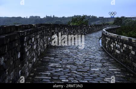 (140813) -- NANCHINO, 13 agosto 2014 -- questa foto scattata il 13 agosto 2014 mostra una vista delle mura della città di Nanchino dalla dinastia Ming e una scultura degli anelli olimpici a Nanchino, capitale della provincia di Jiangsu della Cina orientale, il 13 agosto 2014. I 2° Giochi Olimpici giovanili estivi si terranno a Nanchino dal 16 al 28 agosto. )(zc) (SP)YOG-CHINA-NANJING-CULTURE PurbuxZhaxi PUBLICATIONxNOTxINxCHN Nanjing 13 agosto 2014 questa foto scattata IL 13 agosto 2014 mostra una veduta delle mura della città di Nanchino dalla dinastia Ming e una scultura degli anelli olimpici a Nanjing capitale della provincia di Jiangsu della Cina orientale NELL'agosto Foto Stock