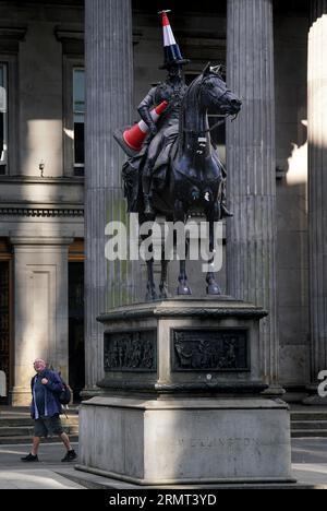 La statua del Duca di Wellington all'esterno della Galleria d'Arte moderna di Glasgow, che è stata adornata con un nuovo cono stradale - con una striscia nera e un'elica in cima. Si ipotizza che l'ultima aggiunta alla famosa statua di Glasgow sia stata messa in atto per segnare la fine della mostra "Cut and Run" di Banksy, chiusa lunedì. Data foto: Mercoledì 30 agosto 2023. Foto Stock