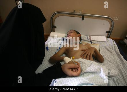 (140814) -- Gaza, 14 agosto 2014 -- madre del bambino palestinese Mohamed Badran tiene la mano mentre riposa all'ospedale di al-Shifa nella città di Gaza l'11 agosto 2014. Badran, un ragazzo di 8 anni a Gaza, si è infortunato e ha perso uno degli occhi in un attacco aereo israeliano sulla casa di famiglia. (Dzl) MIDEAST-GAZA-MILITARY YasserxQudih PUBLICATIONxNOTxINxCHN Gaza 14 agosto 2014 madre di un bambino PALESTINESE Mohamed Badran tiene la mano mentre riposa ALL'ospedale al Shifa di Gaza City L'11 agosto 2014 Badran al ragazzo di Gaza di 8 anni si è infortunato e ha perso uno dei suoi occhi in israeliano SU la sua casa di famiglia dzl Mideast G. Foto Stock