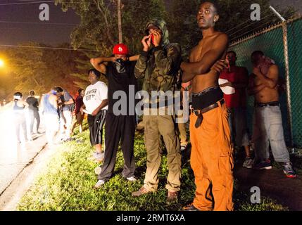 (140819) -- FERGUSON, 19 agosto 2014 -- i manifestanti si trovano sul lato di una strada dopo essere scappati dal fumo di gas lacrimogeni durante le proteste contro l'uccisione di Michael Brown da parte della polizia a Ferguson, Missouri, Stati Uniti. Il diciottenne afroamericano Michael Brown è stato ucciso dalla polizia a Ferguson, scatenando continue proteste nella città dove la maggior parte della popolazione è nera. ) US-MISSOURI-FERGUSON-PROTESTA-CLASH ShenxTing PUBLICATIONxNOTxINxCHN Ferguson 19 agosto 2014 i manifestanti si trovano SUL lato di una strada dopo essere SCAPPATI da Smoke durante la protesta contro l'uccisione di Michael Brown a Fergus da parte della polizia Foto Stock