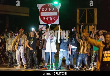 (140819) -- FERGUSON, 19 agosto 2014 -- i manifestanti che portano segnali stradali rotti bloccano la strada durante le proteste contro l'uccisione di Michael Brown da parte della polizia a Ferguson, Missouri, Stati Uniti.il diciottenne afro-americano Michael Brown è stato ucciso dalla polizia a Ferguson, scatenando continue proteste nella città dove la maggior parte della popolazione è nera. ) US-MISSOURI-FERGUSON-PROTESTA-CLASH ShenxTing PUBLICATIONxNOTxINxCHN Ferguson 19 agosto 2014 manifestanti che portano segnali stradali rotti Block the Road durante la protesta contro l'uccisione di Michael Brown da parte della polizia a Ferguson Missouri gli Stati Uniti 18 anni Foto Stock