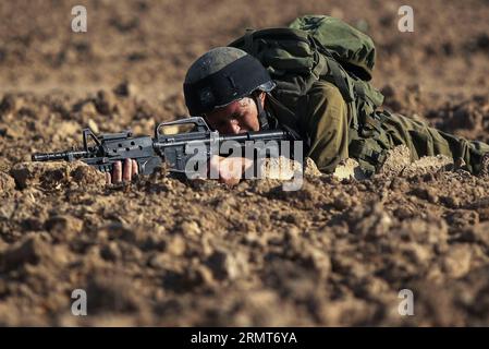 (140819) -- FRONTIERA DI GAZA, 19 agosto 2014 -- un soldato israeliano agisce in un'operazione nel sud di Israele al confine con la Striscia di Gaza, il 19 agosto 2014. Tre palestinesi sono stati uccisi e altri 40 feriti negli intensivi attacchi aerei israeliani sulla città di Gaza martedì sera, poco prima della fine di un cessate il fuoco di 24 ore nella Striscia di Gaza, hanno detto i medici. JINI/) ISRAEL-GAZA-CESSATE IL FUOCO-END IlanxAsayaag PUBLICATIONxNOTxINxCHN frontiera di Gaza 19 agosto 2014 al soldato israeliano agisce per l'operazione nel sud di Israele borde la Striscia di Gaza IL 19 agosto 2014 tre PALESTINESI sono stati UCCISI e altri 40 feriti nella Foto Stock