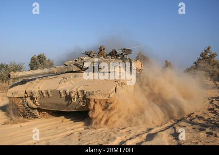 (140819) -- FRONTIERA DI GAZA, 19 agosto 2014 -- un carro armato israeliano Merkava rotola nel sud di Israele al confine con la Striscia di Gaza, il 19 agosto 2014. Tre palestinesi sono stati uccisi e altri 40 feriti negli intensivi attacchi aerei israeliani sulla città di Gaza martedì sera, poco prima della fine di un cessate il fuoco di 24 ore nella Striscia di Gaza, hanno detto i medici. JINI/) ISRAEL-GAZA-CESSATE IL FUOCO-END IlanxAsayaag PUBLICATIONxNOTxINxCHN confine di Gaza 19 agosto 2014 a rulli di carri armati israeliani Merkava nel sud di Israele borde la Striscia di Gaza IL 19 agosto 2014 tre PALESTINESI sono stati UCCISI e altri 40 feriti nell'intensa aria israeliana Foto Stock